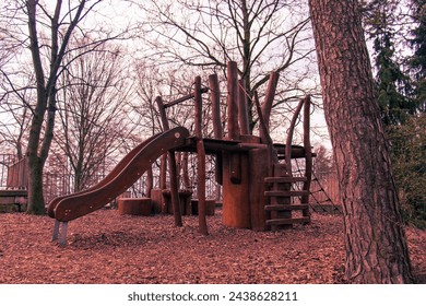 Abstract photo of an abandoned wooden playground in cold winter weather. Abandoned playground, wooden playground in nature, forest, trees, nature, children's playground - Powered by Shutterstock