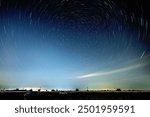 Abstract photo of Blue Night sky star trail background.Startrails on a dark blue sky at night,center sky area.Rotating star lines. The North Star and meteor showers.