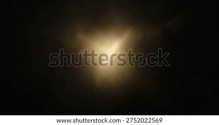 An abstract photo featuring soft, diffused light reflections creating a bokeh effect on a dark background.