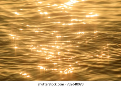 Abstract photo of surface water of sea or ocean at sunset time with golden light tone. - Shutterstock ID 782648098