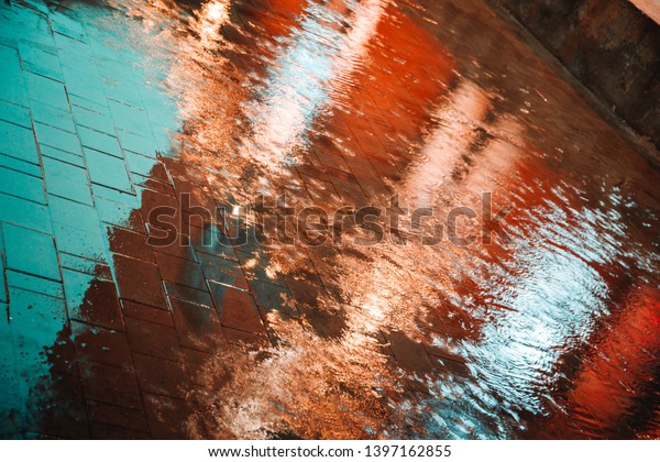 Abstract photography of rain. Raindrops on\
asphalt in the light of evening\
lights.
