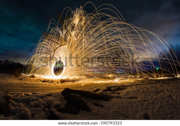 Abstract picture\
with trajectories of burning sparks near the tree at the background\
of spring night\
landscape