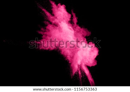 Abstract pink powder splatter on black background.Freeze motion of pink color powder explosion.