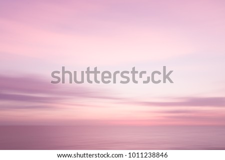Abstract pink sunset sky and ocean nature background with blurred panning motion.