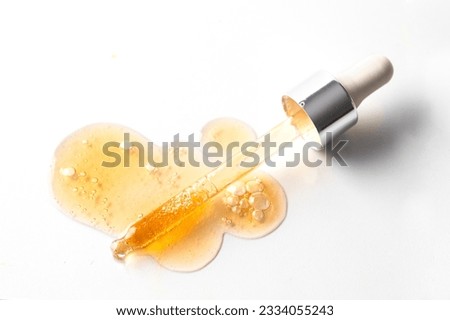 Abstract pipette dropper with orange liquid drops and smer with bubbles onwhite background. Concept for Laboratory investigation, medicine, science research, cosmetic industry