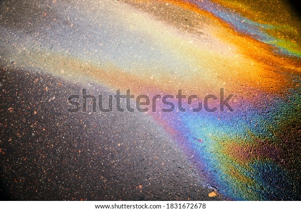 Abstract rainbow effect background, colorful\
gas stain on wet asphalt caused by a leak under a car or truck.\
Texture or Background