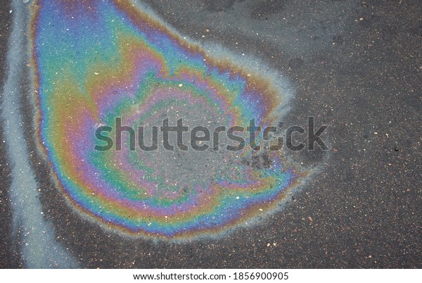 Abstract\
rainbow effect, colorful gas stain on wet asphalt.Rainbow gasoline\
leak after a car on a pedestrian\
sidewalk.