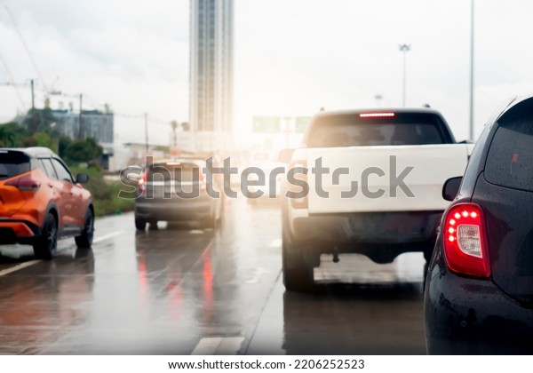 Abstract of rear side of black\
car. Rear side view of car in rainy time and traffic jam. Traffic\
congestion with many queues due to the wet asphalt road surface.\
