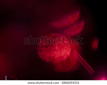 Abstract red light leaks with glowing red light streaks against dark background. Visual effect created by camera movement or light trails. Graphic background for design.