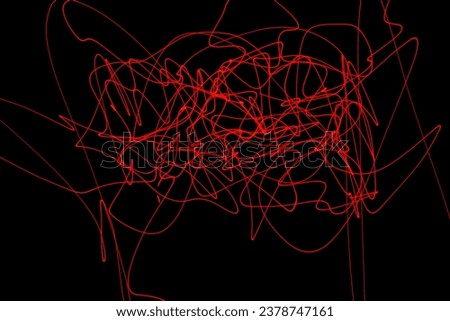 Abstract red lines drawn by light on a black background. Laser lines