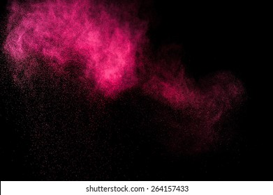 Abstract red and pink powder explosion on black background.
