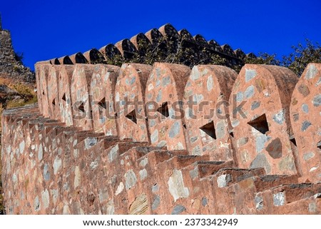Abstract of red stone staircase and protective wall structure. This Can be seen in palaces or fort of India from early centuries. Wall has unique holes to watch, attack enemies and invaders from top.