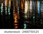 Abstract rendering of the slick pavement of Jaffa Road in downtown Jerusalem illuminated by bright, colorful artificial light on a rainy winter night in Israel. 