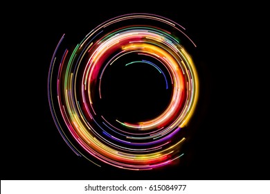 Abstract rotating neon lights texture with black empty copy space.