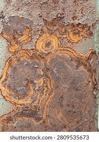 Abstract Rust Texture with Circular Corrosion Pattern on Weathered Metal Surface. 
Close-up of abstract rust texture featuring unique circular corrosion patterns on an old weathered metal surface. Image aspect ratio 3:4.