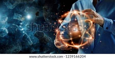 
Abstract science, hands holding atomic particle, nuclear energy imagery and network connection on meteorites space planets background.