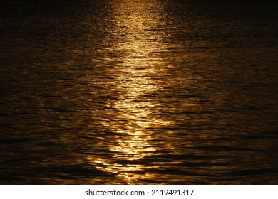 Abstract sea water waves background or texture during sunset, view on ripple surface