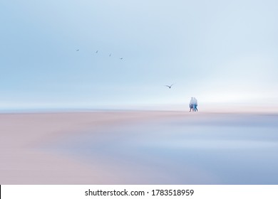 Abstract seascape, motion blur.  Silhouette of couple on the beach at sunrise.