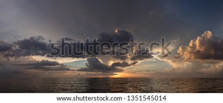 Abstract seascape panoramic background - Orange color in the sky, sunset late afternoon. Calm seas/ocean in the bottom of the frame. Minimalistic simple background image, blue and yellow colors.