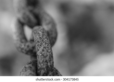 Abstract selective-focus shot of a chain with a very thin layer of sharpness indicating the fragility of a connection
