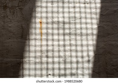 Abstract Shadow Pattwerns Being Cast By The Strairs Of An External Fire Escape Outside A Building