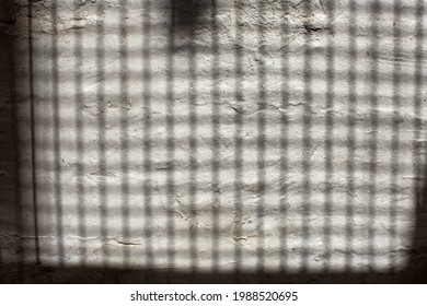 Abstract Shadow Pattwerns Being Cast By The Strairs Of An External Fire Escape Outside A Building