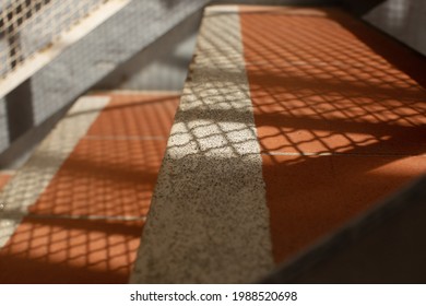 Abstract Shadow Pattwerns Being Cast By The Strairs Of An External Fire Escape Outside A Building