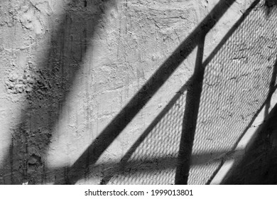 Abstract Shadow Pattwerns Being Cast By The Strairs Of An External Fire Escape Outside A Building