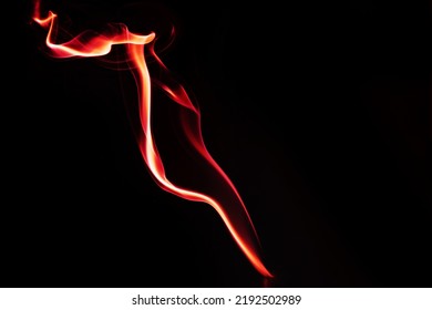 Abstract Shape Of Colored Smoke On A Black Background. Copy Space.