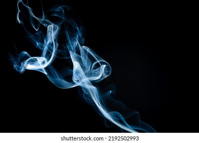 Abstract Shape Of Colored Smoke On A Black Background. Copy Space.