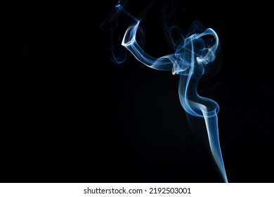 Abstract Shape Of Colored Smoke On A Black Background. Copy Space.