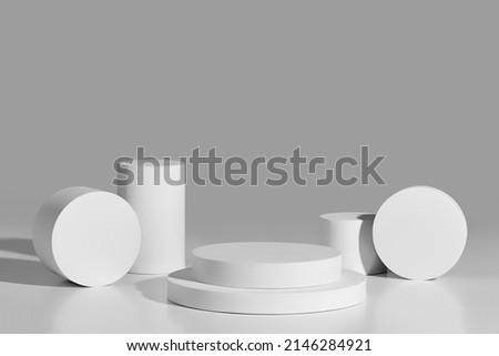 Abstract showcase mockup of two-level round platform and cylinders on gray background