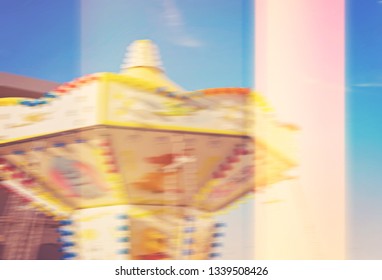 Abstract Slow Motion View Of Rotating Carousel Against Blue Sky With Glitch Light Leak Effect, Blurred Summer Background