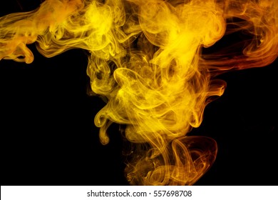Abstract smoke Weipa. Personal vaporizers fragrant steam. The concept of alternative non-nicotine smoking. Yellow smoke on a black background. E-cigarette. Evaporator. Taking Close-up. Vaping.