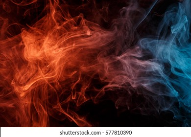 Abstract smoke Weipa. Personal vaporizers fragrant steam. The concept of alternative non-nicotine smoking. Orange turquise smoke on a black background. E-cigarette. Evaporator. Taking Close-up. Vaping
