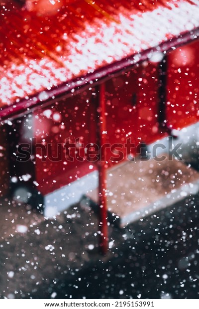 Abstract snowfall in the city against the background\
of a red wall