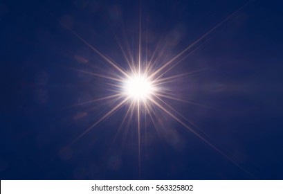 Abstract Sparkling Light Rays And Lighting Flare Bokeh Against On Dark Blue Sky Background