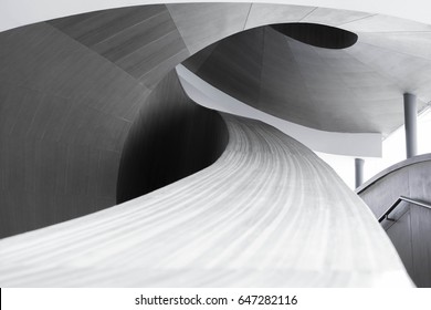 abstract spiraling handrail of a wooden staircase in a modern design building