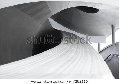 abstract spiraling handrail of a wooden staircase in a modern design building
