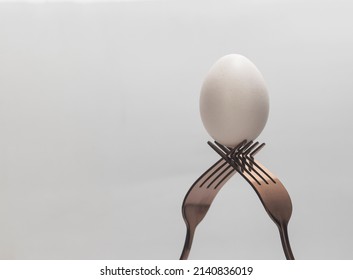 Abstract Still Life, Two Forks And Egg On A White Background
