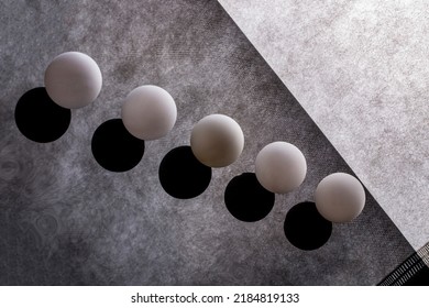 Abstract still life with white balls on a reflective surface