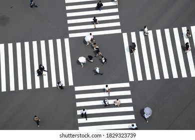 Abstract Street Photo Of Tokyo, Ginza Traffic And People Lifestyle During COVID-19. In The Image Office And Working People Is Crossing The Intersection With Some Holding Umbrella For Sunlight. 