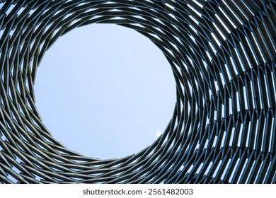 Abstract structure ending in a circle, framing a clear view of the sky. A minimalist and artistic composition blending geometry and nature, inviting contemplation and curiosity