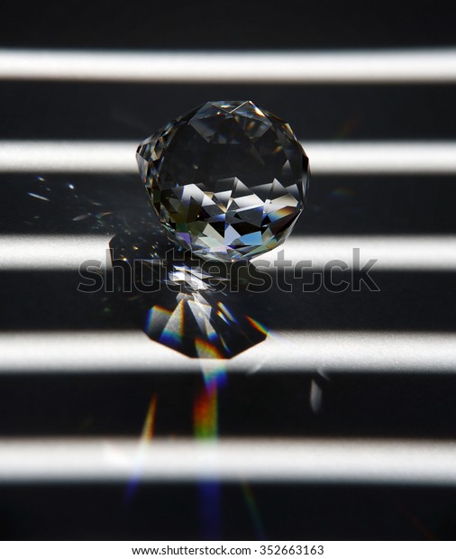 abstract studio photography of a glass diamond and\
broken light in striped\
back