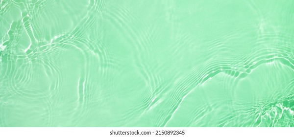 Abstract summer banner background Transparent green clear water surface texture with ripples and splashes. Water wave in sunlight, copy space, top view Cosmetics moisturizer micellar toner emulsion - Shutterstock ID 2150892345