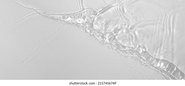 Abstract summer banner background Transparent beige clear water surface texture with ripples and splashes. Water waves in sunlight, copy space, top view. Cosmetics moisturizer micellar toner emulsion - Shutterstock ID 2157456749
