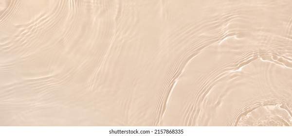 Abstract summer banner background Transparent beige clear water surface texture with ripples and splashes. Water waves in sunlight, copy space, top view. Cosmetics moisturizer micellar toner emulsion - Shutterstock ID 2157868335