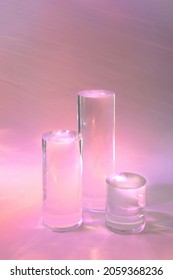 Abstract Surreal Scene - Empty Stage With Three Clear Glass Cylinder Podiums On Pastel Pink Holographic Background In Water. Pedestal For Cosmetic Product Packaging Mockups Display Presentation