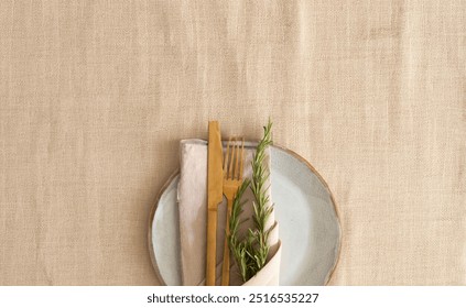 Abstract table setting with artesian plate , gold cutlery, linen napkin decorated with rosemary, Christmas, Thanksgiving, Wedding y etc festive table d?cor - Powered by Shutterstock