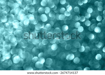 Abstract teal bokeh light pattern creating a dreamy and soft ethereal backdrop.